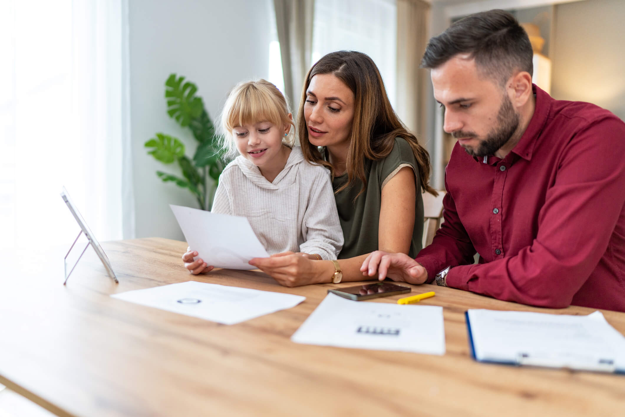 A family at a kitchen table looking at a paperwork
