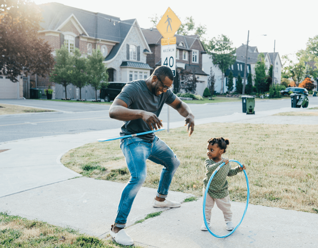 A parent and their child playing in their front yard
